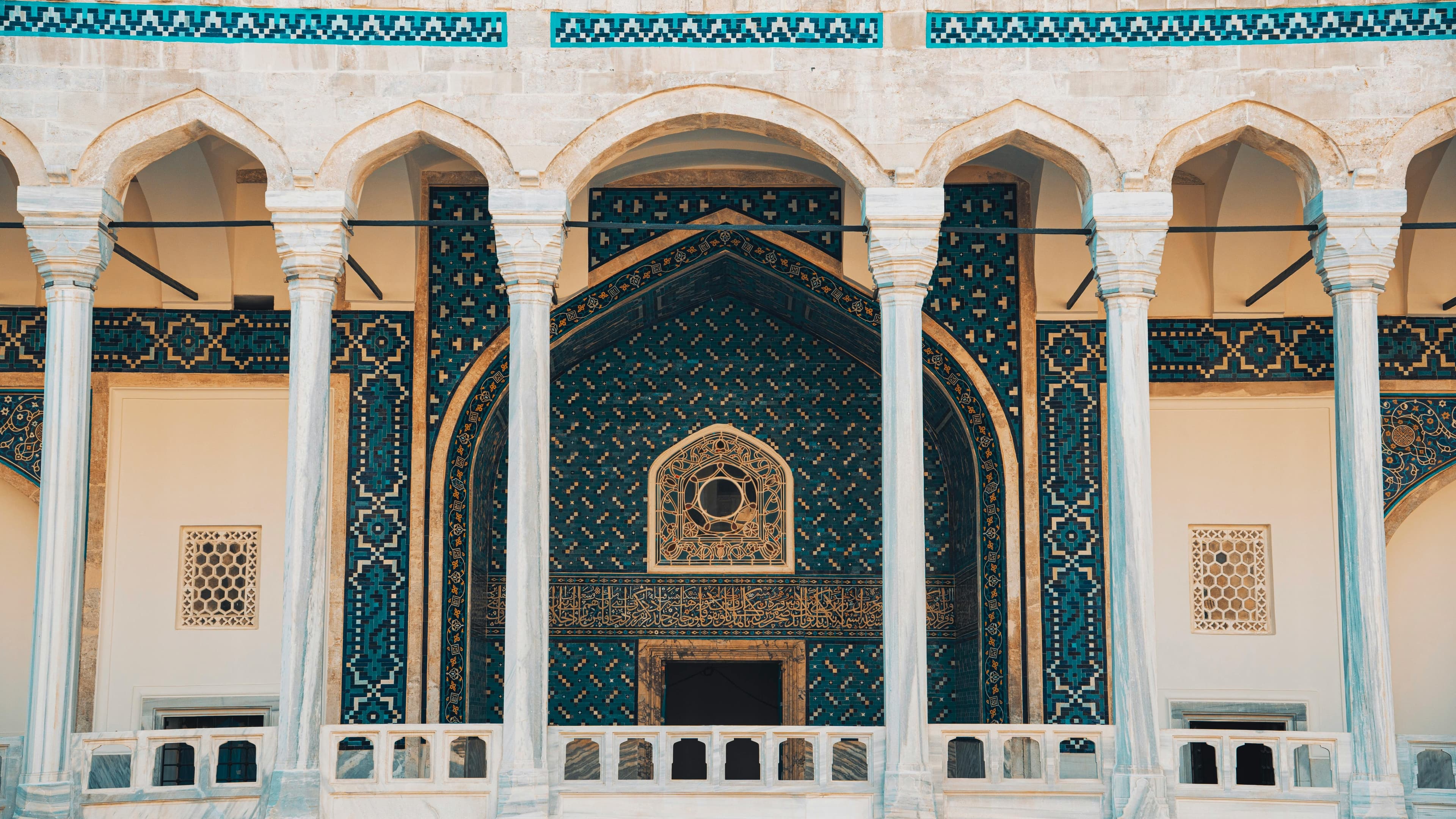 واجهة معمارية مزخرفة بالأعمدة والزخارف الزرقاء لصفحة البرامج المركزة